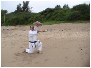 Sensei Brandon Fisher on the beach in Okinawa with the Tinbe & Rochin